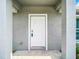 White front door entrance with gray columns and concrete porch at 12128 Grouse Ave, Port Charlotte, FL 33981