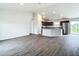 Open living room with wood-look floors and access to the kitchen at 12128 Grouse Ave, Port Charlotte, FL 33981