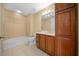 Clean bathroom with a bathtub, toilet and wood cabinets at 5242 Manorwood Dr # 3A, Sarasota, FL 34235