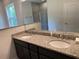 Double vanity bathroom with granite countertop and large mirror at 4619 Chamrade Rd, North Port, FL 34288