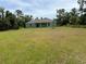 View of the back of the house and large backyard at 4619 Chamrade Rd, North Port, FL 34288