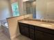 Double vanity bathroom with granite countertop and large mirror at 4619 Chamrade Rd, North Port, FL 34288