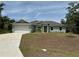 Single-story home with light green exterior, attached garage, and a spacious lawn at 4619 Chamrade Rd, North Port, FL 34288