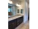 Double vanity bathroom with granite countertops and dark cabinets at 3481 Nashville Rd, North Port, FL 34288