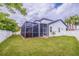 A well-manicured backyard features a white fence, a screened-in patio, and lush green grass at 205 Bengal Cir, Oldsmar, FL 34677