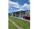 Mobile home with covered patio and carport,red car parked nearby at 6480 Center Lane, North Port, FL 34287