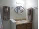 Bathroom featuring a single vanity, framed mirror, and organized towel racks for convenience and elegance at 4469 Keyes Ave, Spring Hill, FL 34606