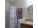 Shower showcasing a decorative ocean-themed curtain, adding a splash of color to the neutral-toned bathroom at 4469 Keyes Ave, Spring Hill, FL 34606