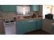 Cozy kitchen with light teal cabinets, white appliances, and butcher block countertops at 7316 Tropical Dr, Weeki Wachee, FL 34607