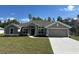Charming single-story home featuring a well-manicured lawn, neutral color palette, and an attached two-car garage at 12283 Ipswich Sparrow Rd, Weeki Wachee, FL 34614