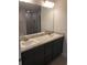 Bathroom featuring double sinks, dark vanity, and a large mirror at 324 Galaxy Ave, Spring Hill, FL 34606