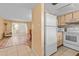 Kitchen with white appliances and light wood cabinets at 4901 Onyx Ln # 101, New Port Richey, FL 34652