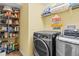 Bright laundry room with washer, dryer, and ample storage shelving at 19617 Sunset Bay Dr, Land O Lakes, FL 34638
