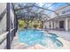 Relaxing freeform pool with fountain feature in a screened enclosure at 19617 Sunset Bay Dr, Land O Lakes, FL 34638