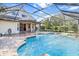 Inviting freeform pool with a water feature in a screened patio at 19617 Sunset Bay Dr, Land O Lakes, FL 34638