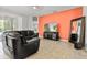 Spacious living room features a black leather couch, large TV, and tile flooring at 19617 Sunset Bay Dr, Land O Lakes, FL 34638