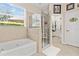 Bathroom with a soaking tub, walk-in shower, and window at 19617 Sunset Bay Dr, Land O Lakes, FL 34638
