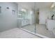 Modern bathroom with double vanity, walk-in shower, and glass enclosure at 13744 Carryback Dr, Dade City, FL 33525