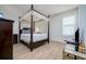Elegant bedroom with four-poster bed, wood floors, and plantation shutters at 13744 Carryback Dr, Dade City, FL 33525