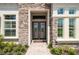 Elegant double front doors with glass inserts and stone surround at 13744 Carryback Dr, Dade City, FL 33525