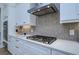 Gas cooktop with modern backsplash and white shaker cabinets at 13744 Carryback Dr, Dade City, FL 33525