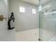Large walk-in shower with gray tile, built-in seat, and glass enclosure at 13744 Carryback Dr, Dade City, FL 33525