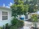 Side view of a light teal home with a walkway and landscaping at 3390 Lambert Ave, Spring Hill, FL 34608