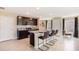 Open-concept kitchen with island seating, dark cabinets, and stainless steel appliances at 30942 Wild Juniper Ct, Brooksville, FL 34602