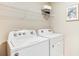 A laundry room with a Whirlpool washer and dryer and overhead storage at 30942 Wild Juniper Ct, Brooksville, FL 34602