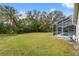 Expansive backyard featuring a screened pool and lush greenery at 8550 Berkley Dr, Hudson, FL 34667