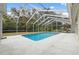 Screened rectangular pool with concrete deck and lush landscaping at 8550 Berkley Dr, Hudson, FL 34667