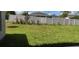 A spacious backyard features lush green grass and a white vinyl fence, creating a private outdoor space at 13221 Gulf Bay Ln, Spring Hill, FL 34609