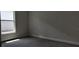A bright bedroom features neutral walls, gray carpeting, a double-hung window and a simple white baseboard at 13221 Gulf Bay Ln, Spring Hill, FL 34609