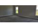 Bright bedroom with neutral walls, carpet, and large windows providing natural light at 13221 Gulf Bay Ln, Spring Hill, FL 34609