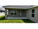 A covered patio featuring gray walls, a door, windows and an outside view of the backyard at 13221 Gulf Bay Ln, Spring Hill, FL 34609