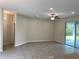 Bright living room with tiled floors, ceiling fan, and sliding glass doors to the outside at 7724 Swiss Ave, North Port, FL 34291