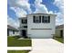 Charming two-story home featuring a two-car garage, simple landscaping and a well-manicured lawn at 30908 Wild Juniper Ct, Brooksville, FL 34602