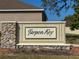 Stone entrance sign for Tarpon Key, a beautiful community, set against a lush landscape at 1280 Windy Bay Shl, Tarpon Springs, FL 34689