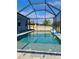 Screened-in pool area with clear water and a basketball hoop, perfect for Gathering fun at 1280 Windy Bay Shl, Tarpon Springs, FL 34689