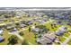 A sunny aerial view of a sprawling neighborhood of green lawns and homes near the coast at 2457 Tamworth Ter, Punta Gorda, FL 33983