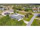An aerial view of a blue home with an enclosed patio and a spacious lawn in a quiet neighborhood at 2457 Tamworth Ter, Punta Gorda, FL 33983