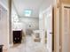 Bright bathroom featuring a soaking tub, tiled shower, and dark wood vanity under a skylight at 2457 Tamworth Ter, Punta Gorda, FL 33983