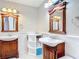 Bathroom featuring double sinks with custom wood cabinets and decorative mirrors at 2457 Tamworth Ter, Punta Gorda, FL 33983