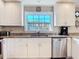 Bright kitchen featuring stainless steel appliances, white cabinets and sink with a view at 2457 Tamworth Ter, Punta Gorda, FL 33983