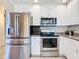 Modern kitchen features stainless steel appliances, granite countertops, and white cabinetry for a clean, updated look at 2457 Tamworth Ter, Punta Gorda, FL 33983