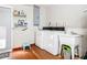 Bright laundry room featuring tile floors, washer, dryer, storage shelf, and utility sink at 2457 Tamworth Ter, Punta Gorda, FL 33983