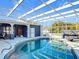 Sparkling pool area enclosed with screened cage, features poolside seating and well-maintained landscaping at 2457 Tamworth Ter, Punta Gorda, FL 33983
