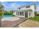 Expansive backyard featuring a sparkling pool, lush tropical landscaping, and multiple gathering spaces at 1731 Clearwater Harbor Dr, Largo, FL 33770