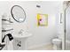 Well-lit bathroom with a sleek pedestal sink, patterned floors, and modern fixtures at 1731 Clearwater Harbor Dr, Largo, FL 33770