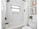 Newly remodeled bathroom featuring a shower-tub combination, modern fixtures and minimalist decor at 1731 Clearwater Harbor Dr, Largo, FL 33770